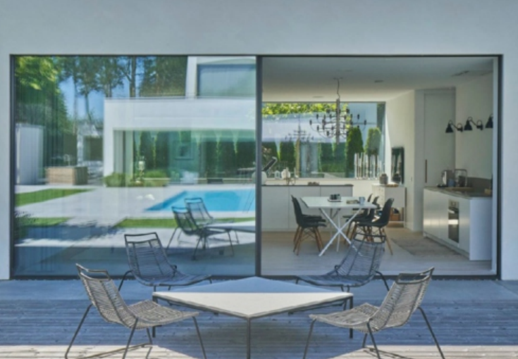 PRM-125 Series slim sliding aluminum door showing multi-panel glass system with garden view