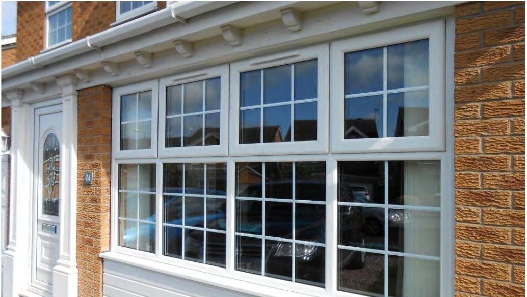 White uPVC casement windows with grille on traditional brick facade