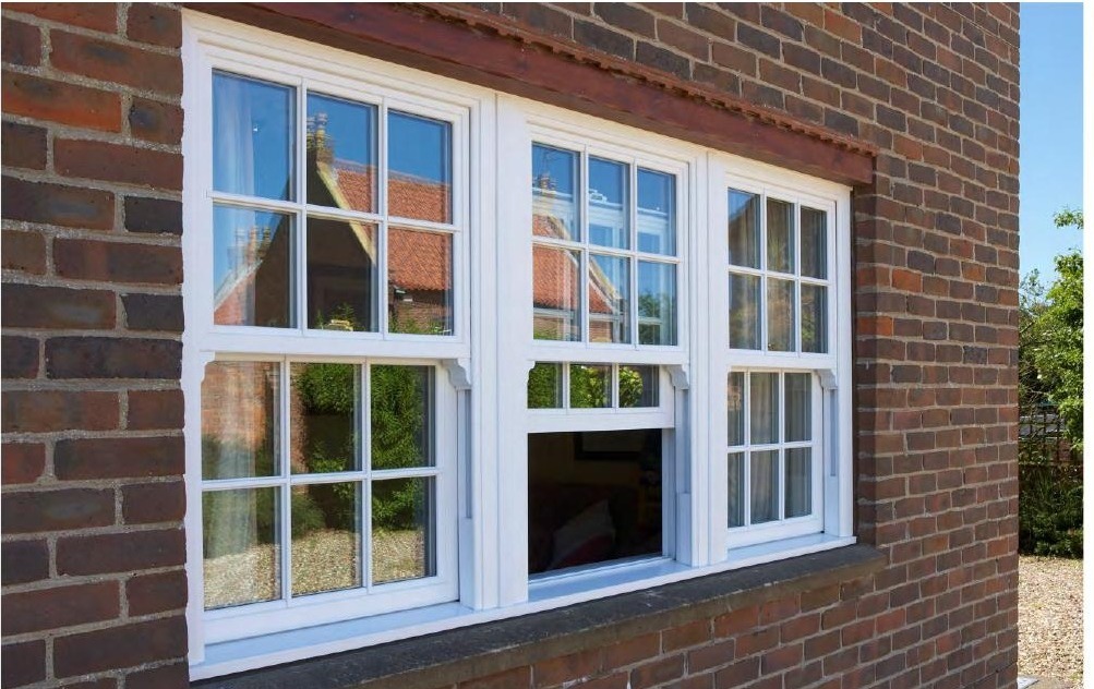 White uPVC double hung windows with grilles on red-brick exterior