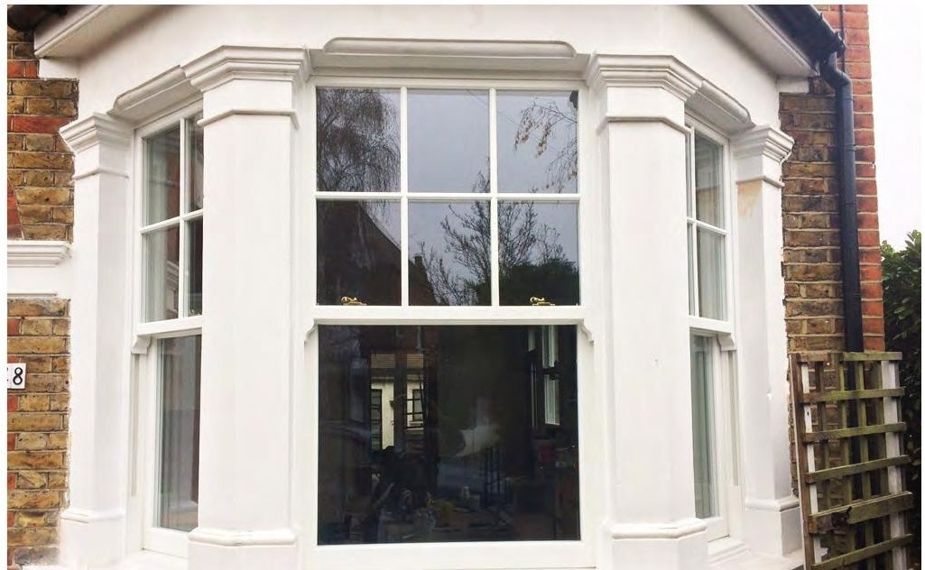White uPVC sash bay window installation on brick facade